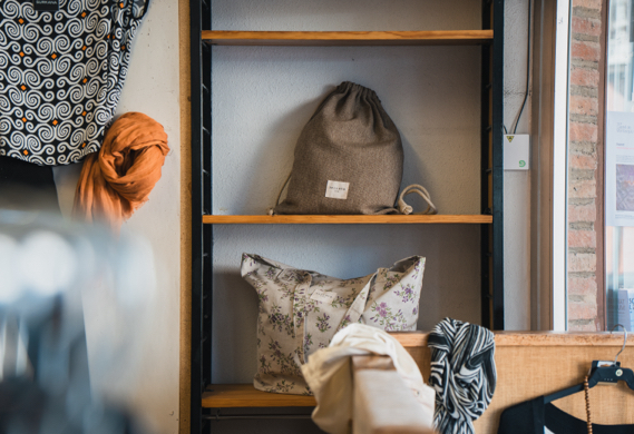 Prestatge amb barret de palla, escultura ceràmica i gerro amb planta.